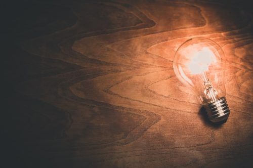 机の上で弱く光る電球の画像